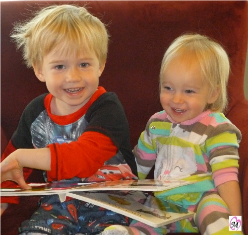 3 year old reading to 1 year old sister